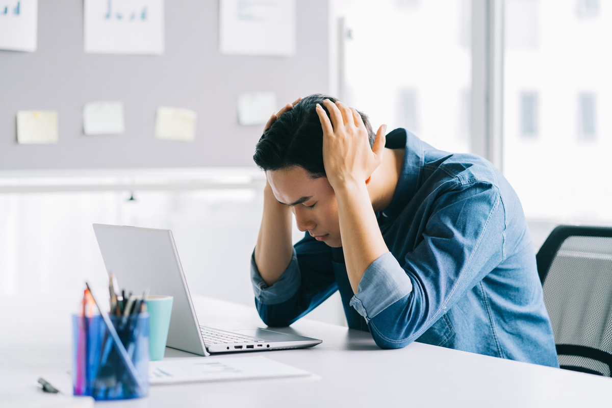 The Asian Man Is Holding His Head Tired of Having to Work Too Much