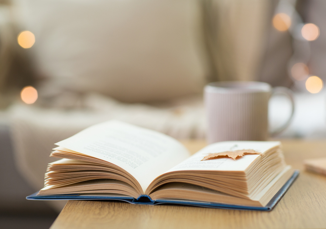 Book with Autumn Leaf on Wooden Table